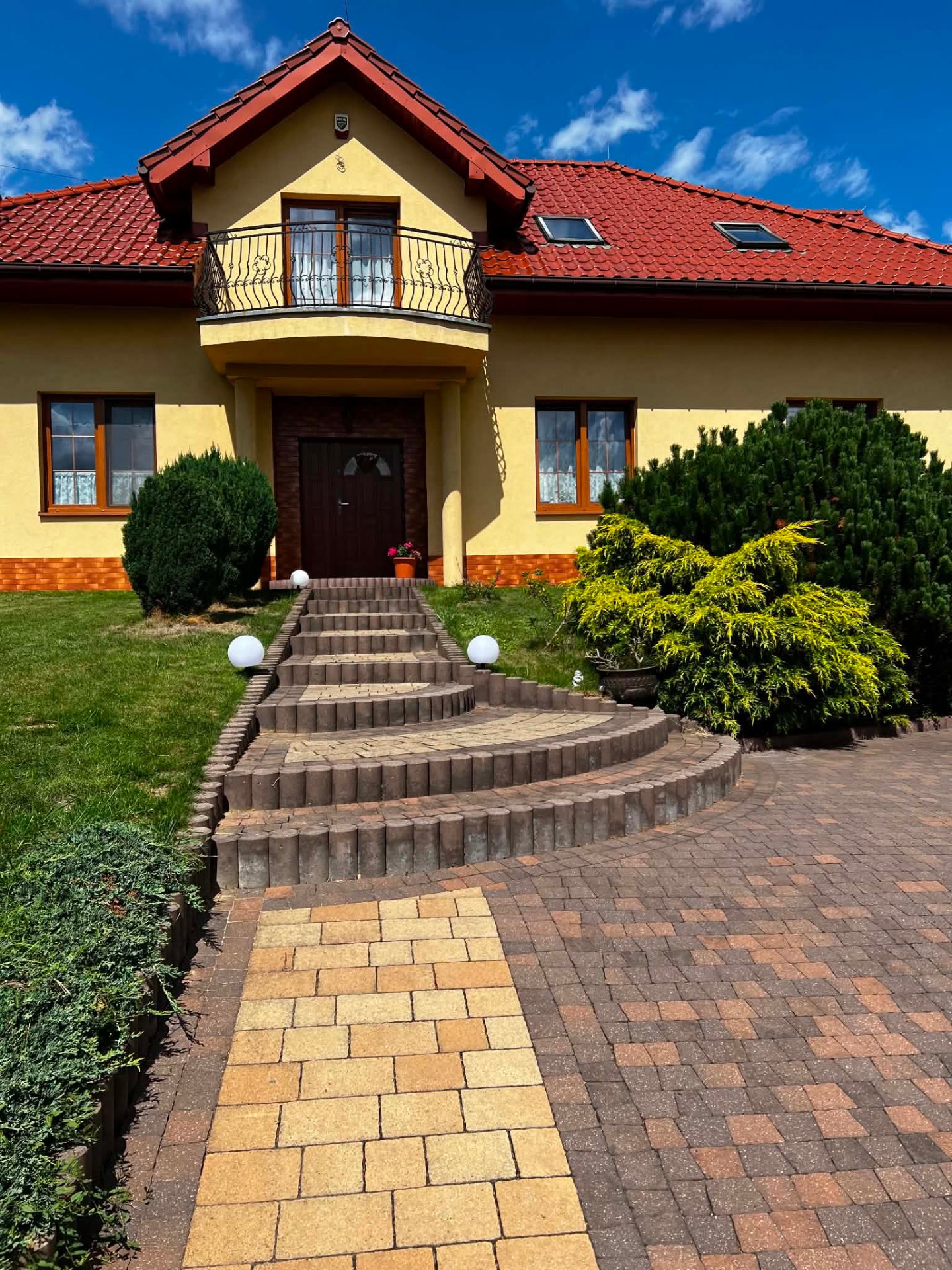 Front domu z podjazdem i ogrodem